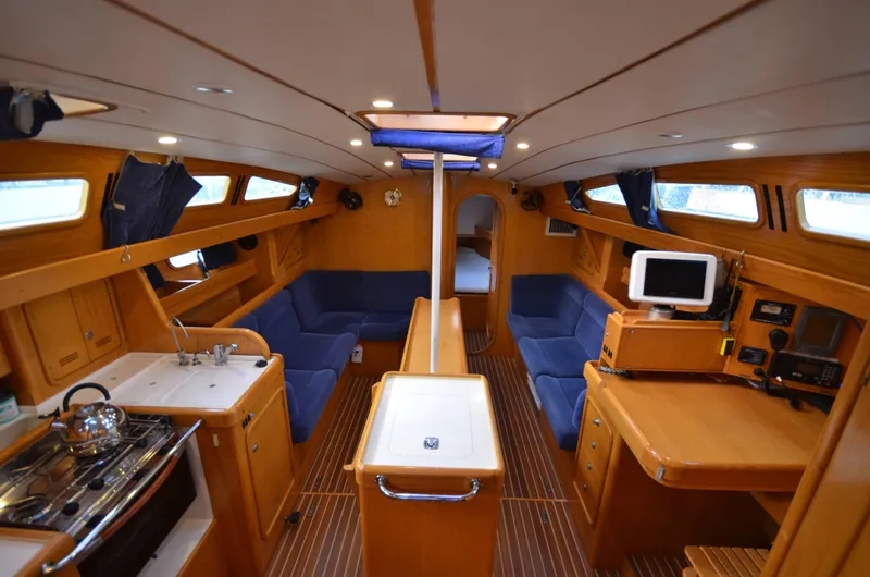 Monica Yacht Photos Pics Interior of 2006 Alubat Ovni 395 Centerboard yacht with wood finish and blue seating.