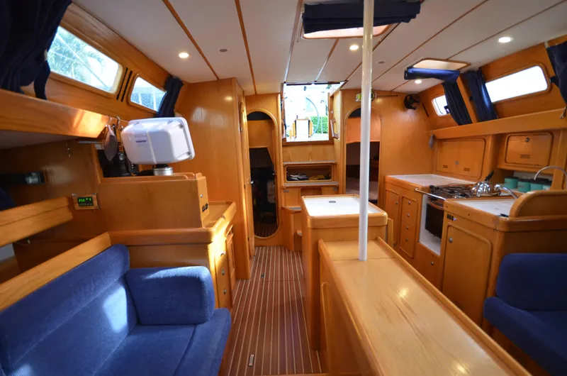 Monica Yacht Photos Pics Interior of 2006 Alubat Ovni 395 Centerboard yacht with wooden finish and blue seating.