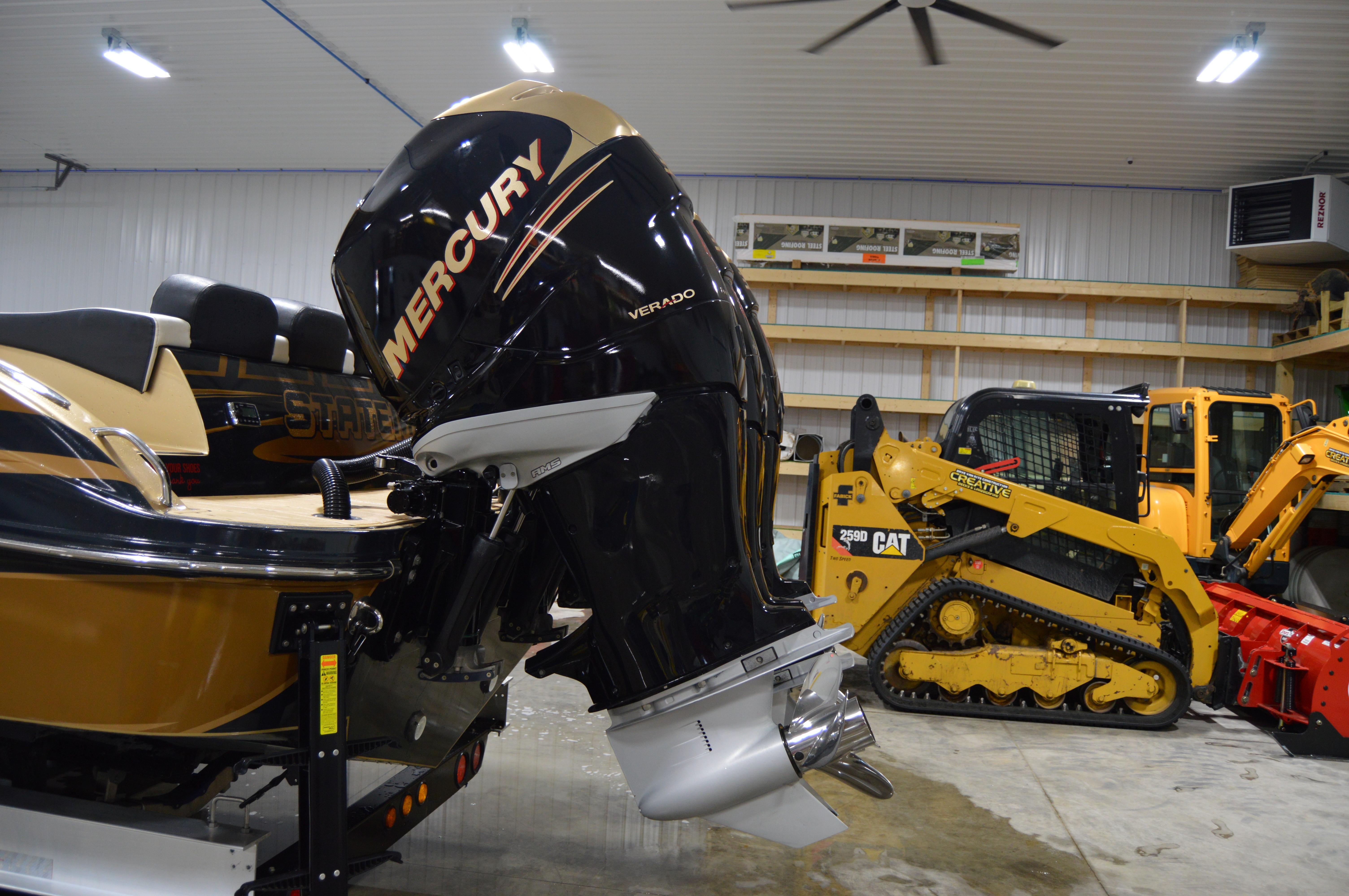 2017 Statement 380 Open boat with Mercury outboard engine in a garage.