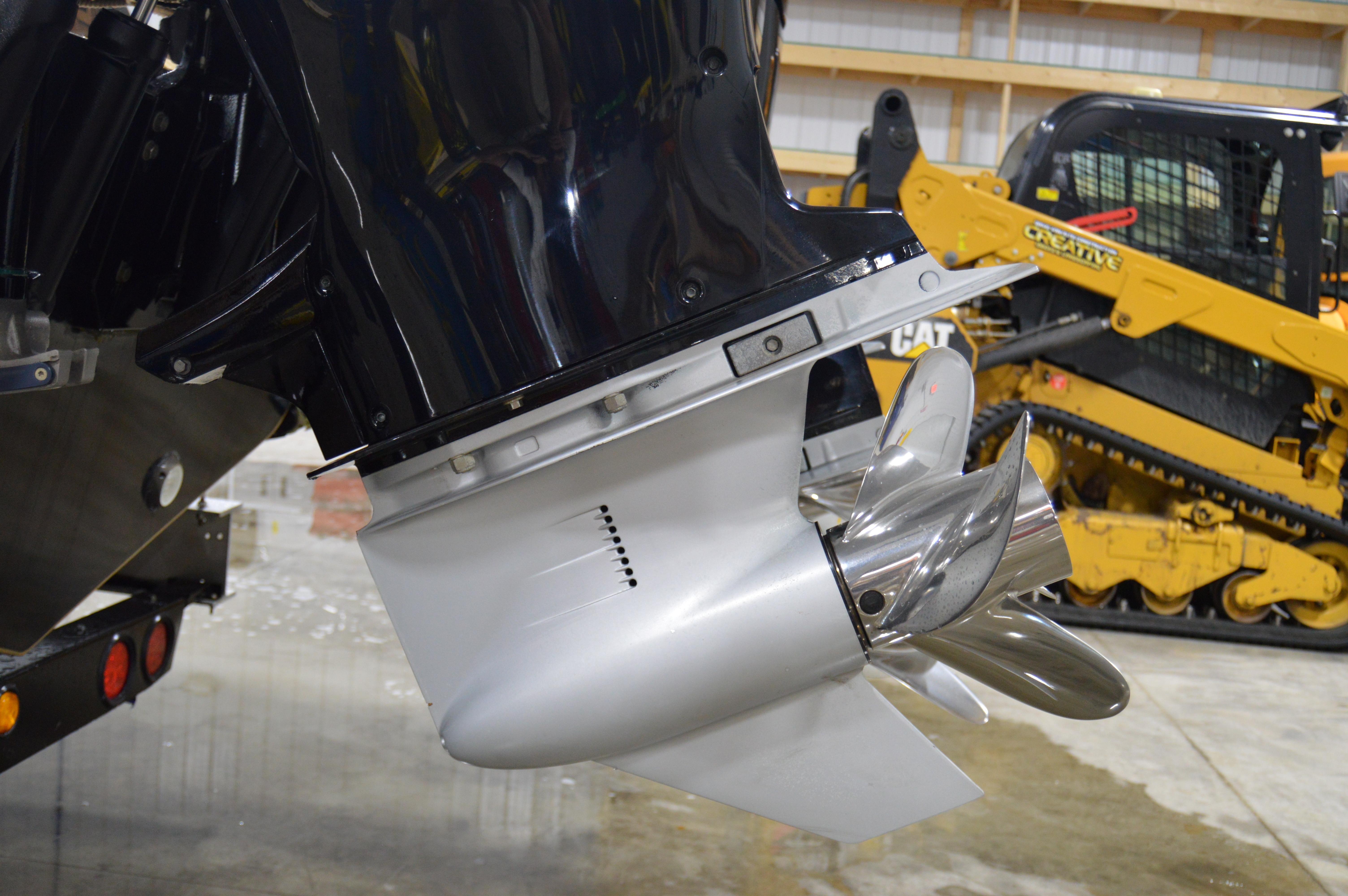 Outboard motor of 2017 Statement 380 Open boat, with construction equipment in the background.