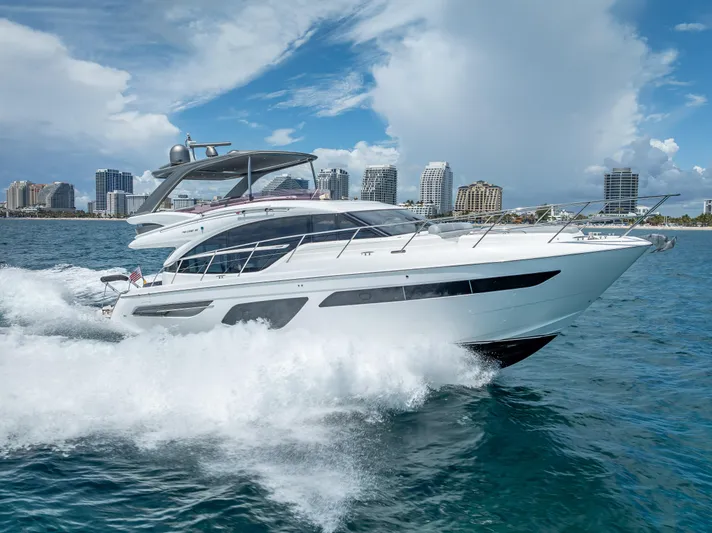  Yacht Photos Pics 2018 Princess F55 yacht cruising on ocean with city skyline in background.