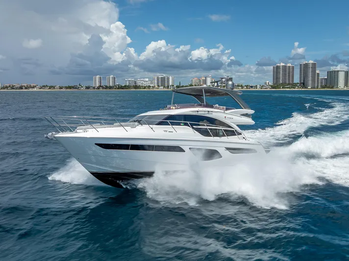  Yacht Photos Pics 2018 Princess F55 yacht cruising on ocean with city skyline in background.