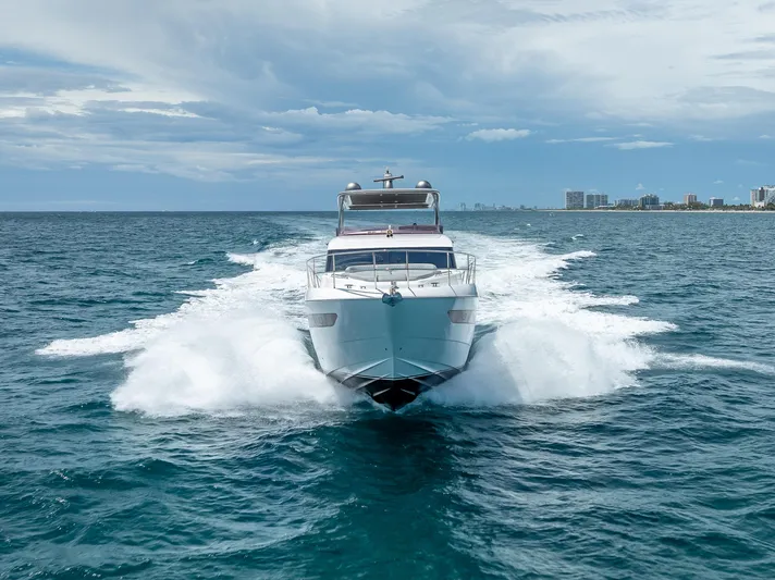  Yacht Photos Pics Luxurious 2018 Princess F55 yacht cruising on open sea with city skyline backdrop.