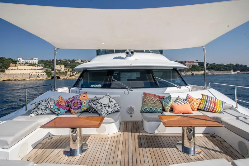 Safad Yacht Photos Pics Luxury 2015 Benetti 121 yacht with shaded deck, colorful cushions, and scenic coastal backdrop.