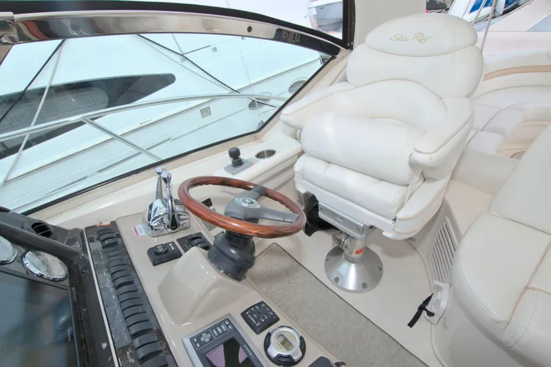  Yacht Photos Pics 2009 Sea Ray 44 Sundancer helm with luxurious white seating and wooden steering wheel.