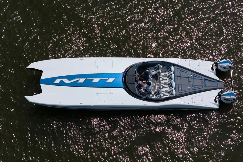 El Gato Yacht Photos Pics Aerial view of 2022 MTI 390X speedboat on shimmering water.