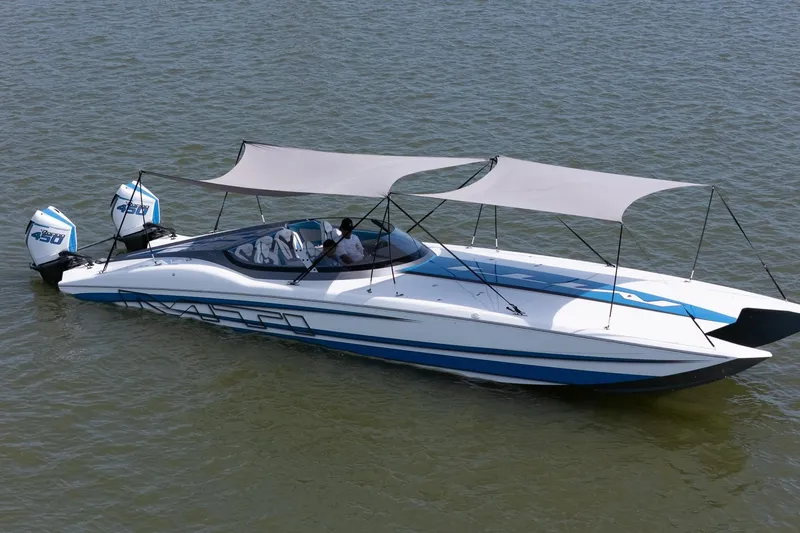 El Gato Yacht Photos Pics 2022 MTI 390X powerboat with dual 450 engines, featuring sunshades, on calm water.