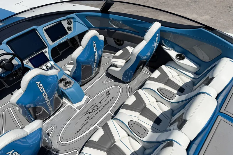 El Gato Yacht Photos Pics Interior of 2022 MTI 390X boat with blue and white seating, advanced dashboard.