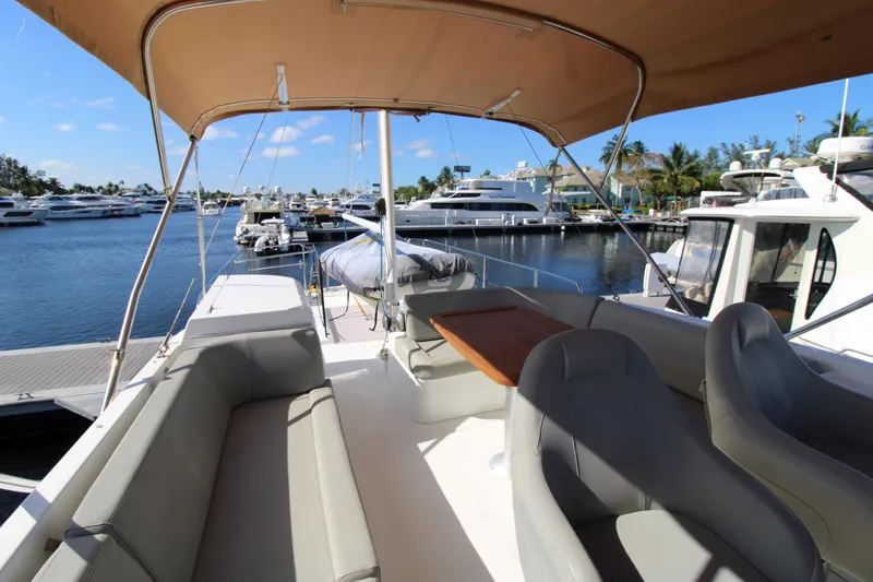 Next Chapter Yacht Photos Pics 2014 Beneteau Swift Trawler 44 flybridge with seating and table, docked at marina.