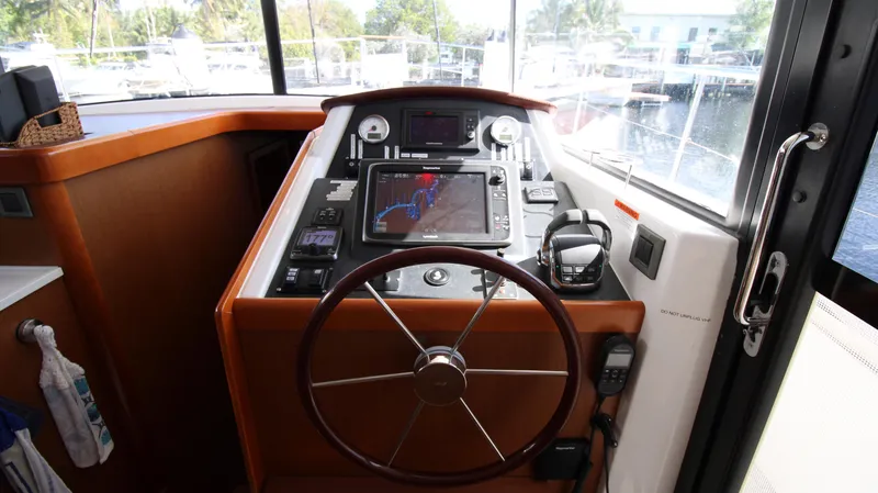 Next Chapter Yacht Photos Pics Helm station of 2014 Beneteau Swift Trawler 44 with navigation equipment and steering wheel.