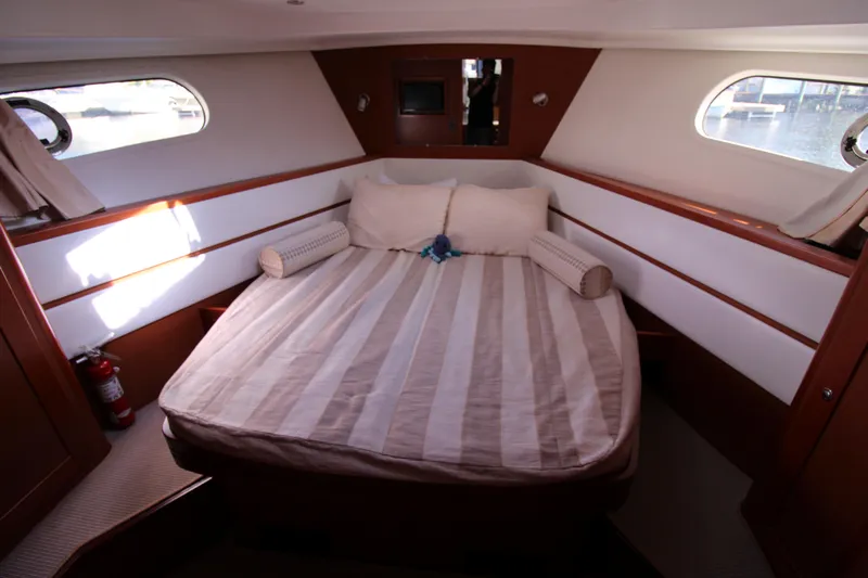 Next Chapter Yacht Photos Pics 2014 Beneteau Swift Trawler 44 master cabin with double bed and porthole windows.