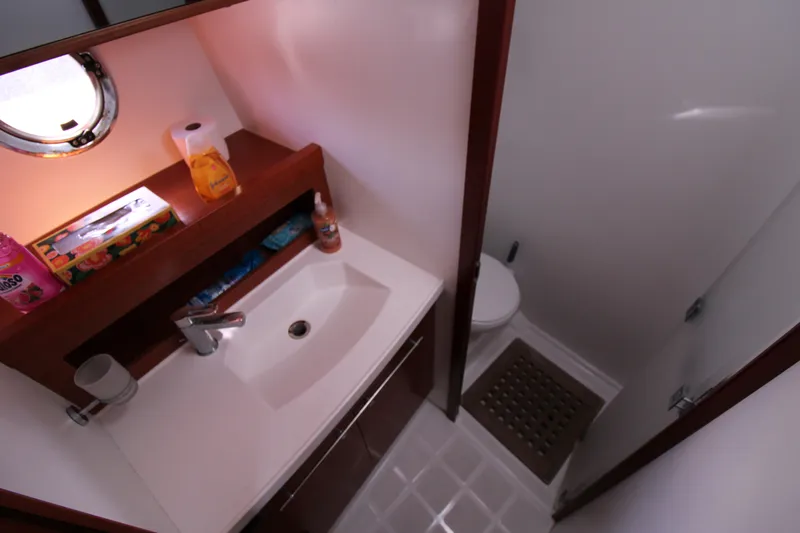 Next Chapter Yacht Photos Pics 2014 Beneteau Swift Trawler 44 bathroom with sink, toilet, and storage shelf.