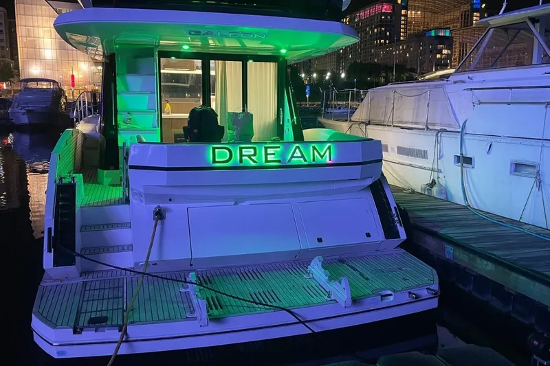  Yacht Photos Pics 2019 Galeon 470 Sky yacht docked at night with green lights and "Dream" sign.