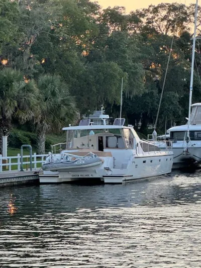 Bobcat Yacht Photos Pics 2010 Cruiser Cats Havana 38 docked by lush greenery and calm waters.