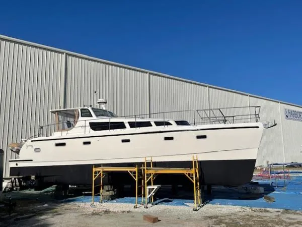 Bobcat Yacht Photos Pics Cruiser Cats Havana 38 catamaran from 2010 on dry dock, against a large warehouse.