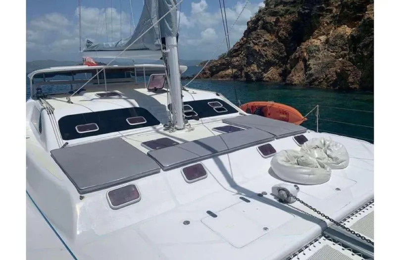 Chef De Mere Yacht Photos Pics 2006 Royal Cape Catamarans 50 sailing near rocky coastline under clear skies.