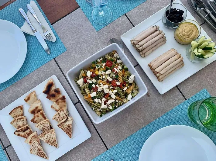 Chef De Mere Yacht Photos Pics Mediterranean meal with pasta salad, pita, and appetizers on a Royal Cape Catamarans 50.