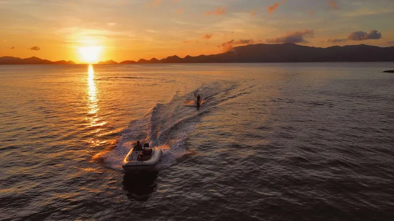 Chef De Mere Yacht Photos Pics Sunset over ocean with boat and water skier, Royal Cape Catamarans 50, 2006.