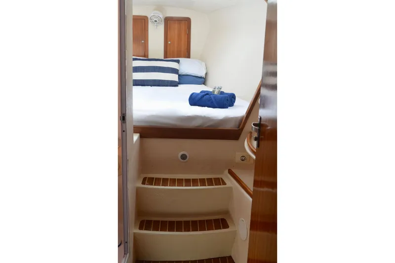 Chef De Mere Yacht Photos Pics Cozy cabin interior of 2006 Royal Cape Catamarans 50 with bed and wooden steps.