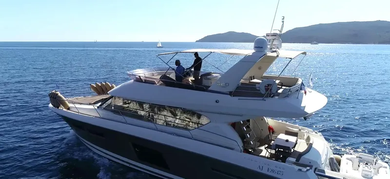  Yacht Photos Pics Luxury 2013 Prestige 620 yacht cruising on open sea with scenic background.