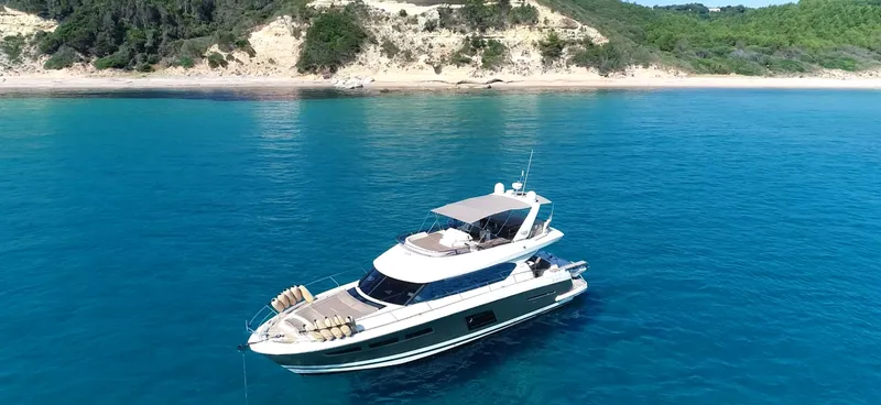  Yacht Photos Pics Luxurious 2013 Prestige 620 yacht cruising in clear blue waters near a scenic coastline.