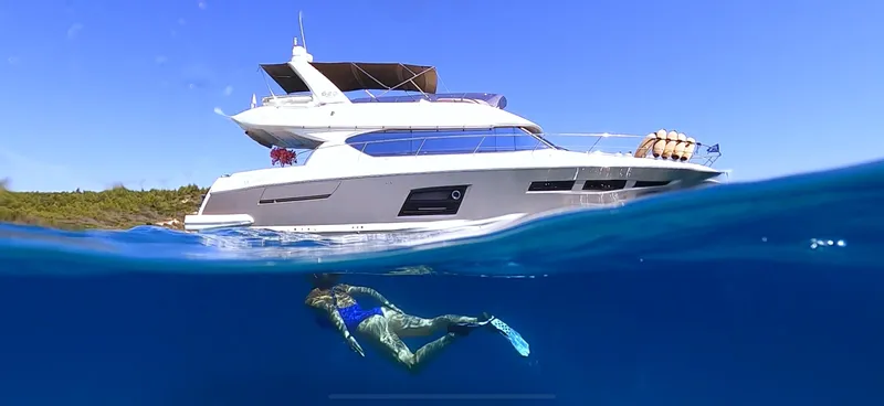  Yacht Photos Pics A 2013 Prestige 620 yacht with a snorkeler in clear blue water.
