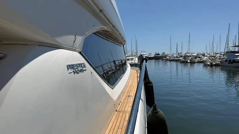  Yacht Photos Pics 2013 Prestige 620 yacht docked in a marina, reflecting clear blue sky and water.