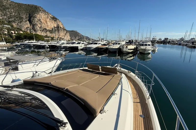  Yacht Photos Pics Prestige 620 yacht, 2013 model, docked in a marina with scenic mountain backdrop.
