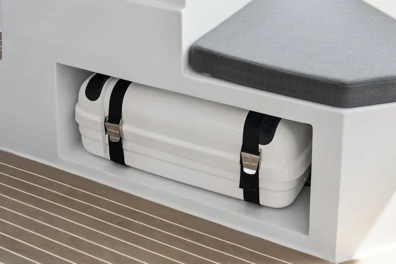 Carolina Red Yacht Photos Pics 2024 St Francis 460 boat storage compartment with secured white case and cushioned seating.