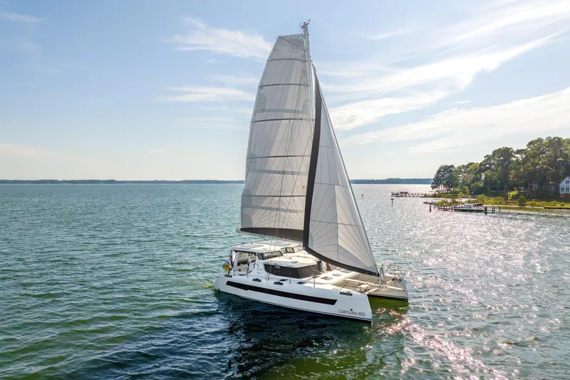 Carolina Red Yacht Photos Pics 2024 St Francis 460 catamaran sailing on a sunny day near the coastline.