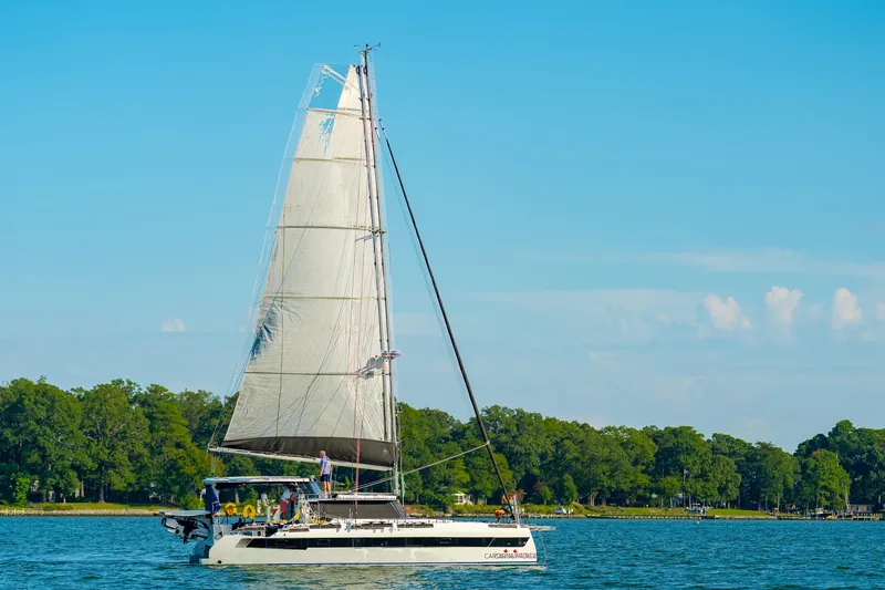 Carolina Red Yacht Photos Pics 2024 St Francis 460 sailboat cruising on a serene lake with lush green shoreline.