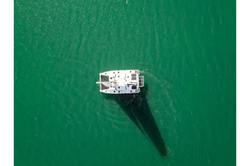 Carolina Red Yacht Photos Pics Aerial view of 2024 St Francis 460 catamaran sailing on clear green water.