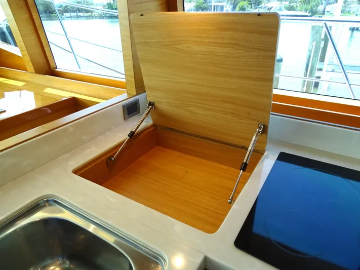 Quintessa Yacht Photos Pics Modern yacht kitchen with wooden storage compartment, stainless steel sink, and sleek cooktop. Horizon PC52, 2014.