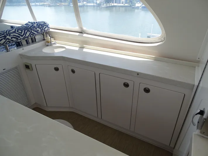 Quintessa Yacht Photos Pics Interior view of 2014 Horizon PC52 yacht with white cabinetry and waterfront window.