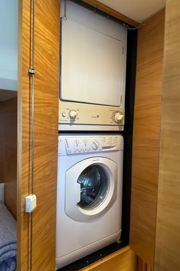 Quintessa Yacht Photos Pics Stacked washer and dryer in wooden cabinet on Horizon PC52 yacht, 2014 model.