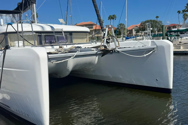 Southern Wild Yacht Photos Pics 2018 Lagoon 40 catamaran docked in marina, clear sky, palm trees in background.