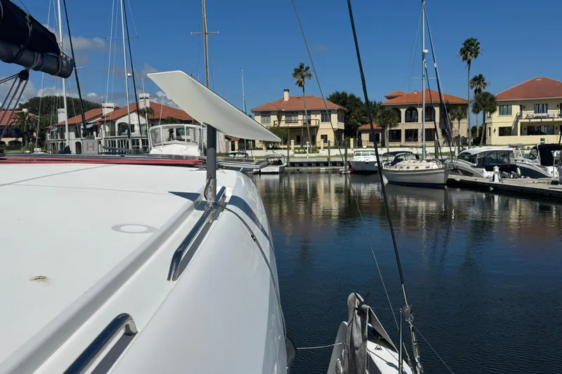 Southern Wild Yacht Photos Pics Lagoon 40 catamaran docked at marina, 2018 model, with waterfront homes in background.
