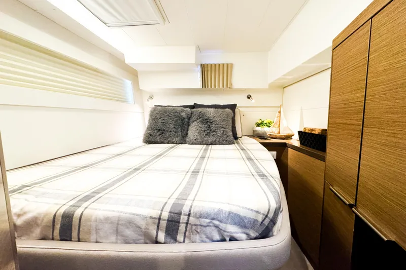 Southern Wild Yacht Photos Pics Cozy bedroom interior of 2018 Lagoon 40 yacht with plush bedding and wooden cabinetry.