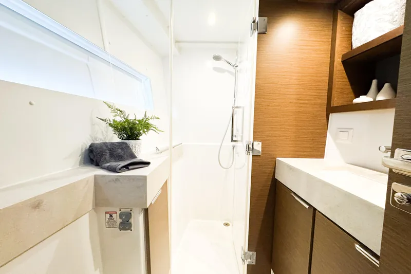 Southern Wild Yacht Photos Pics Modern bathroom interior of 2018 Lagoon 40 yacht with shower and wooden cabinetry.