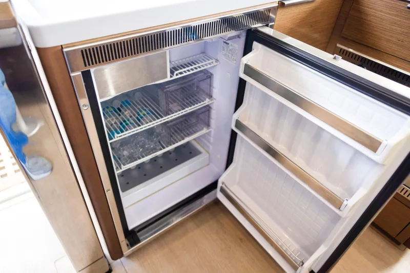 Southern Wild Yacht Photos Pics Open refrigerator inside 2018 Lagoon 40 yacht, showcasing organized shelves and modern design.
