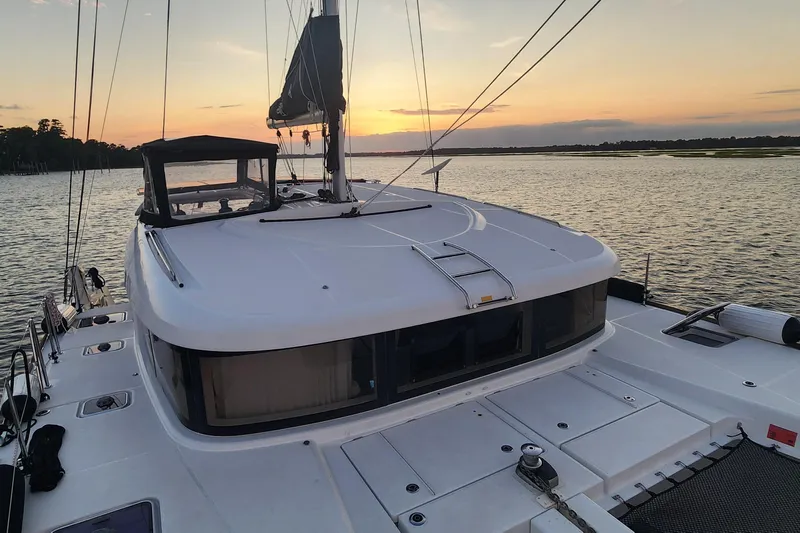 Southern Wild Yacht Photos Pics 2018 Lagoon 40 catamaran at sunset on tranquil water.