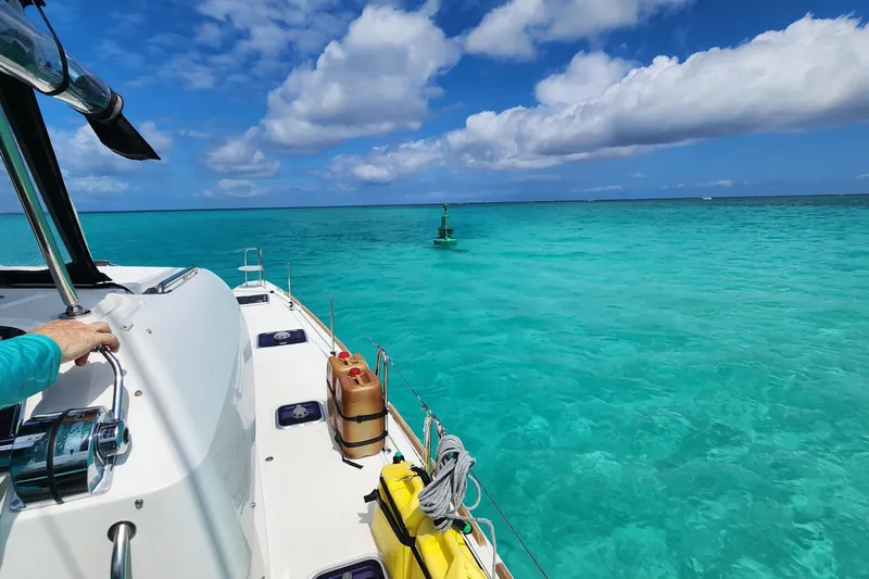 Southern Wild Yacht Photos Pics Lagoon 40 catamaran sailing in clear turquoise waters under a partly cloudy sky.