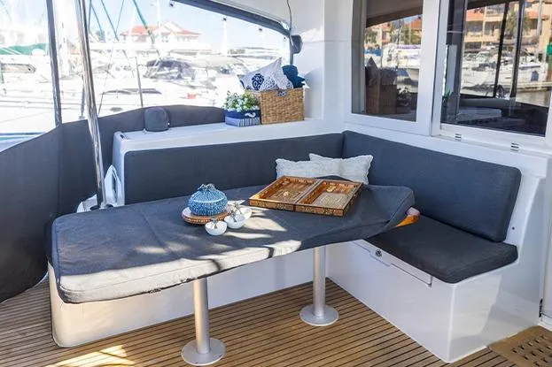 Southern Wild Yacht Photos Pics Cozy seating area on 2018 Lagoon 40 catamaran with table and cushions, docked at marina.