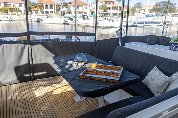 Southern Wild Yacht Photos Pics Cozy seating area on 2018 Lagoon 40 catamaran with game board and marina view.