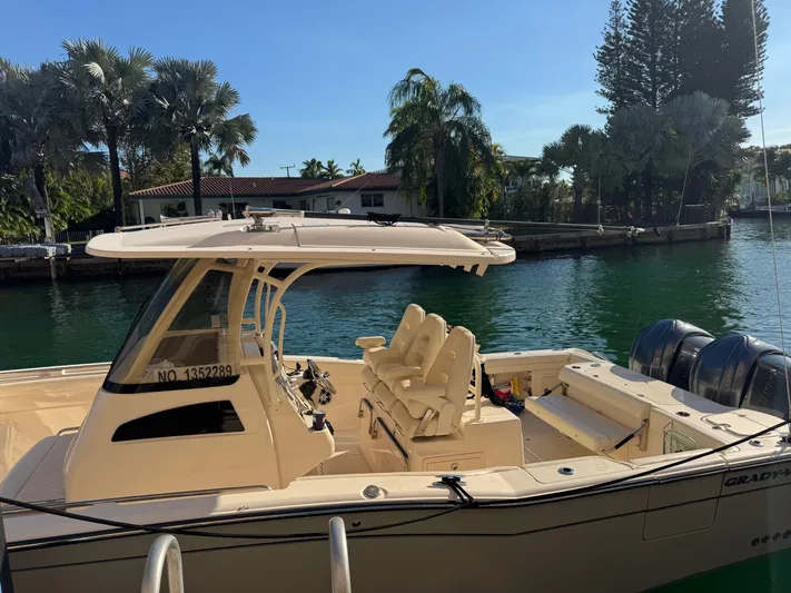 Bugs And Brew Yacht Photos Pics 2024 Grady-White 326 CAN boat docked by water with palm trees.