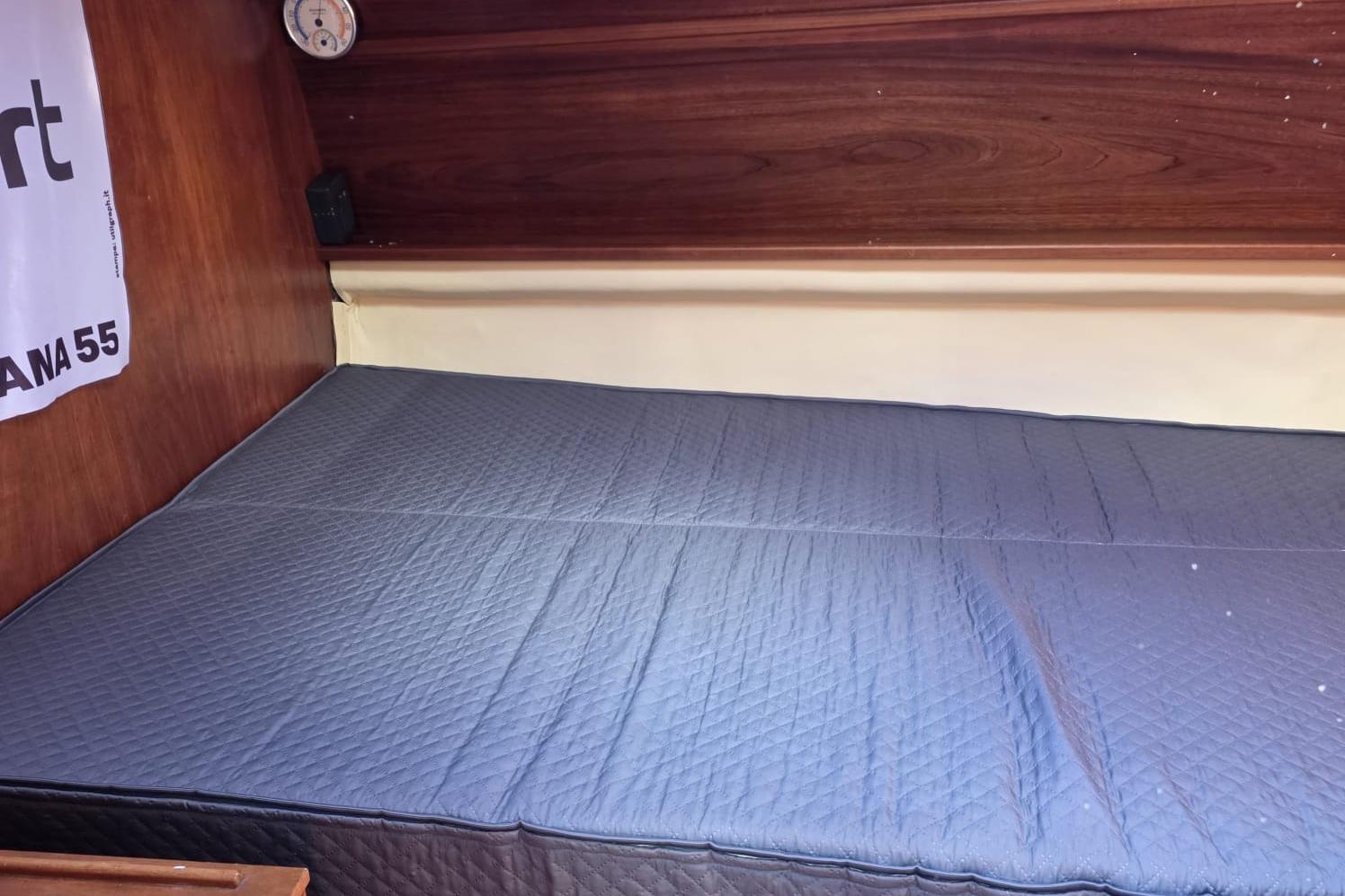 Interior cabin of 1981 Comar Comet 11 sailboat with quilted bedding.