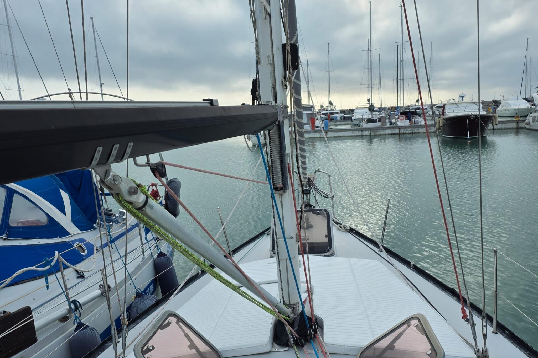 1981 Comar Comet 11 sailboat docked in a marina, overcast sky.