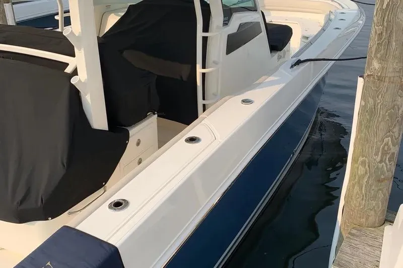  Yacht Photos Pics 2019 Boston Whaler 380 Outrage docked, featuring sleek design and covered seating.