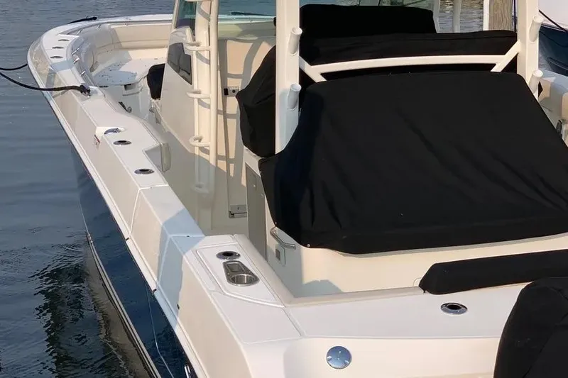  Yacht Photos Pics 2019 Boston Whaler 380 Outrage boat docked, featuring sleek design and covered seating.