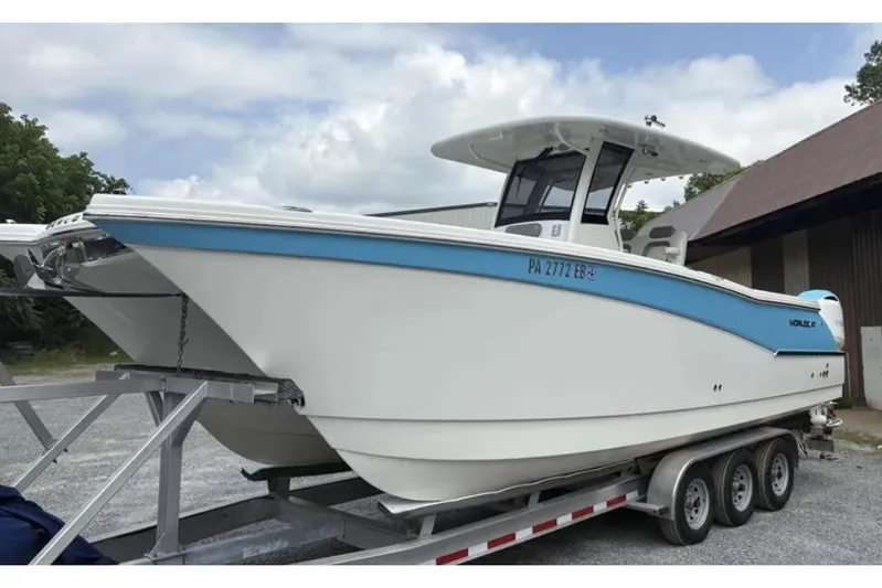  Yacht Photos Pics 2020 World Cat 280 CC-X boat on trailer, white with blue accents, parked outdoors.